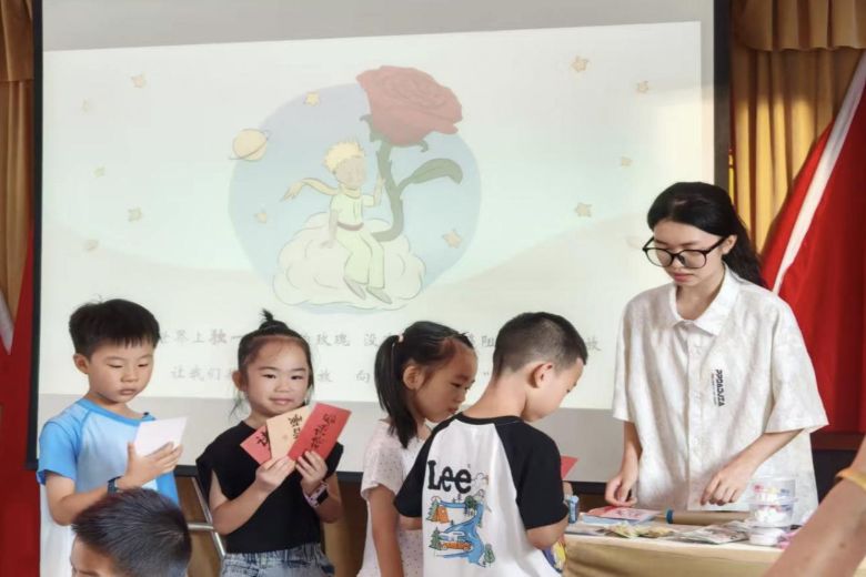 (志愿者为小朋友发放精美小奖品。李雯倩 供图)