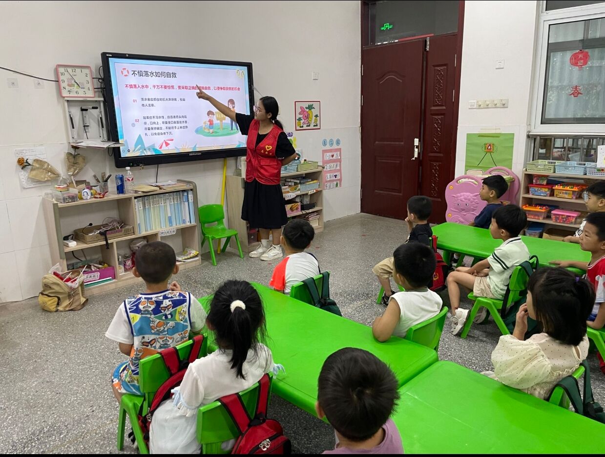 图为实践队员为小朋友讲解不慎落水如何自救